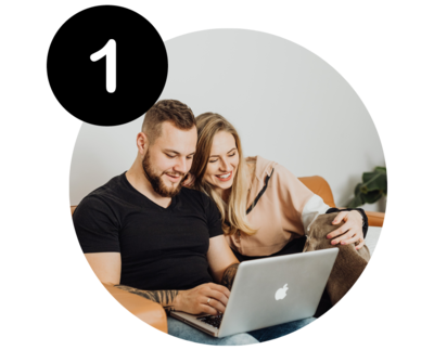 Man using laptop while woman looks on smiling
